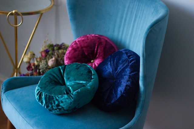 Three round velvet throw pillows on a chair